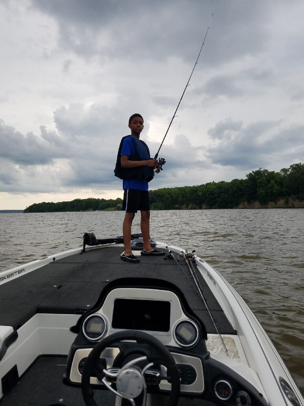 Child learning bass fishing on boat